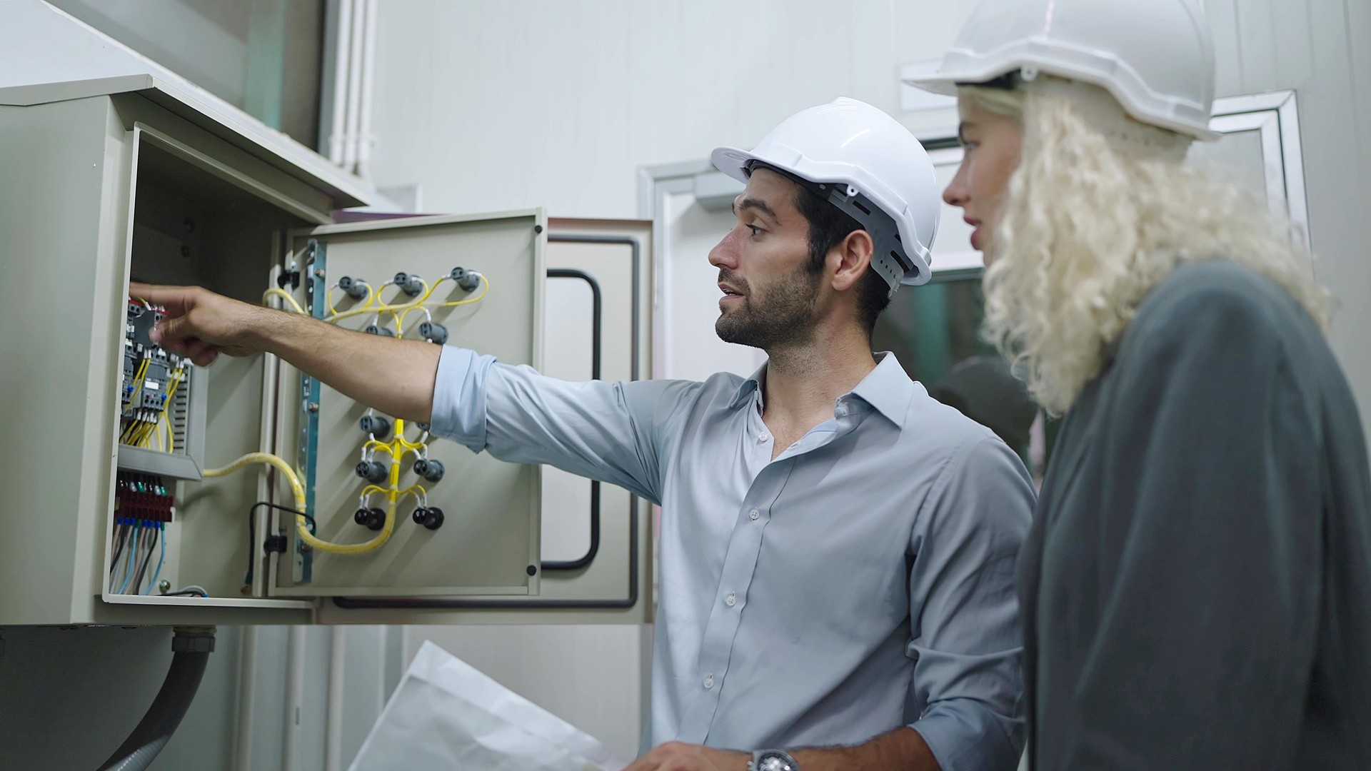 Eletricista, trabalhador, operário e mulher, gerente de fábrica, trabalhando e verificando painel de controle elétrico em fábrica industrial